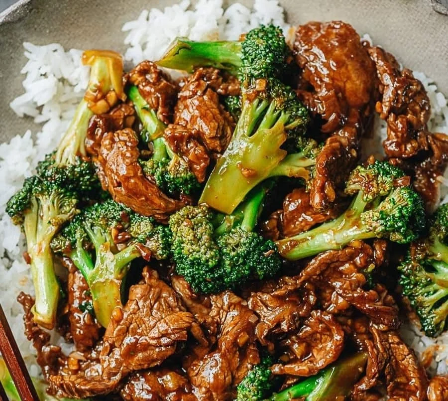 One pan Chinese beef and broccoli dish served with rice and vegetables
