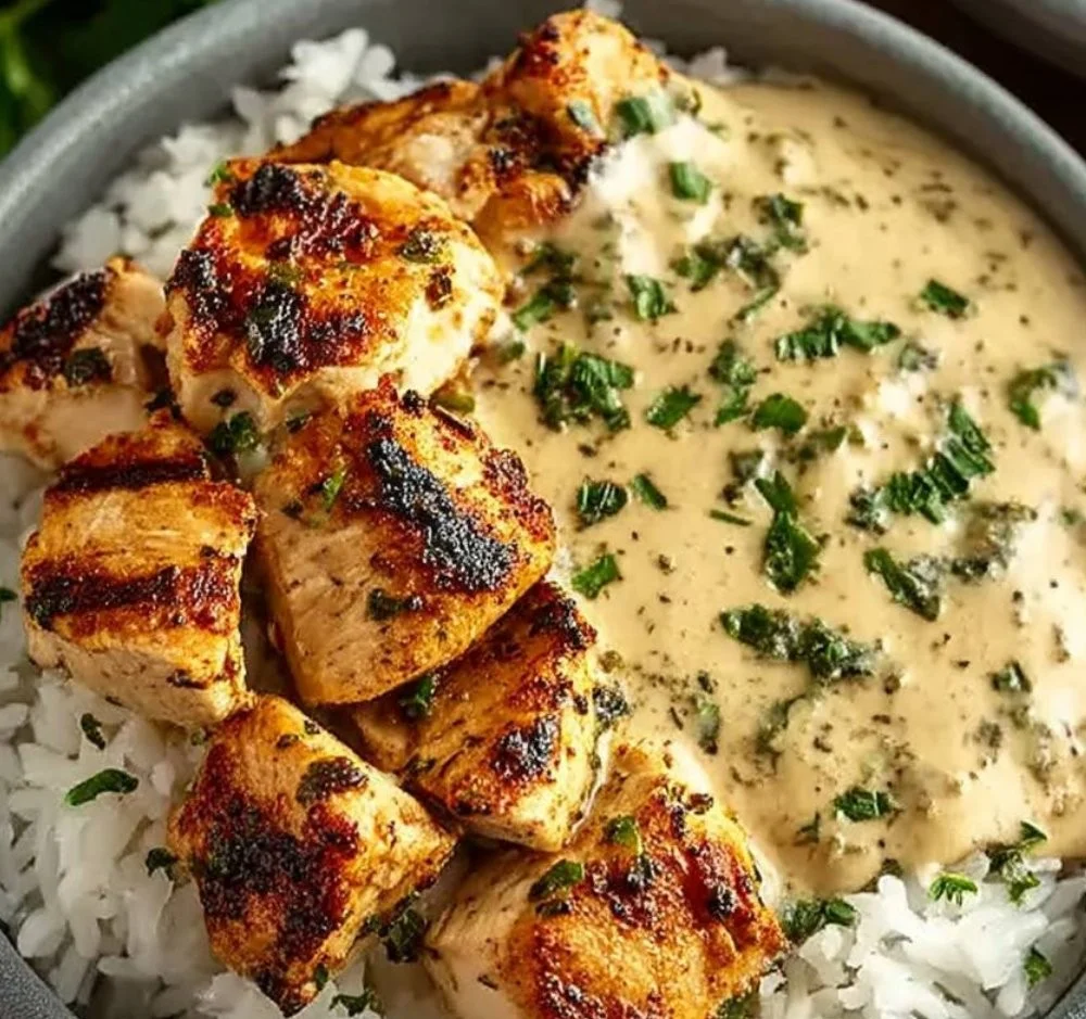 Creamy garlic chicken rice bowl topped with herbs and served in a bowl.