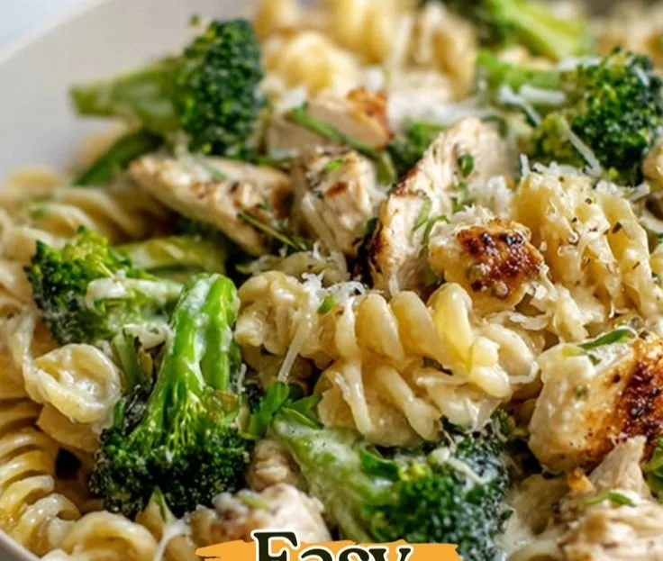Creamy rotisserie chicken broccoli pasta dish garnished with fresh herbs.