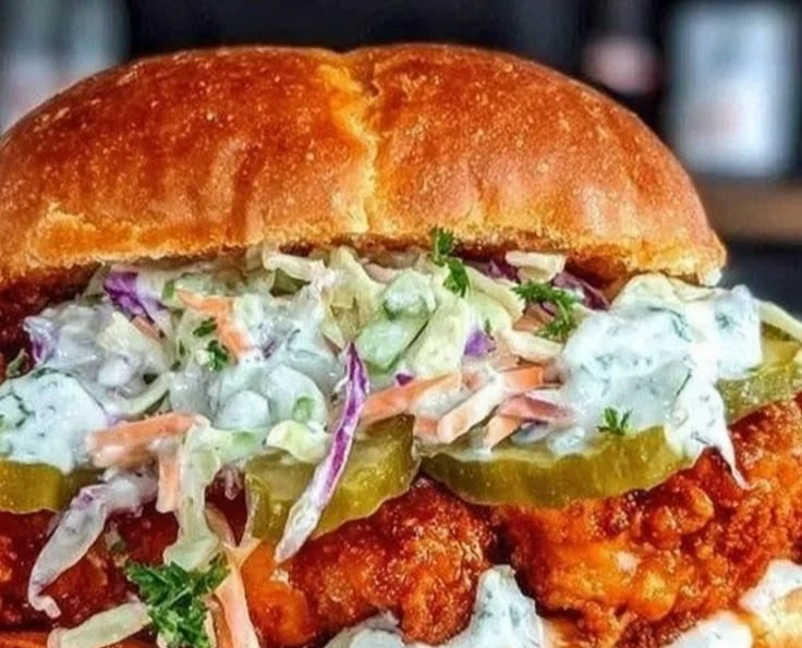 Crispy Buffalo chicken sandwich with ranch slaw on a rustic plate