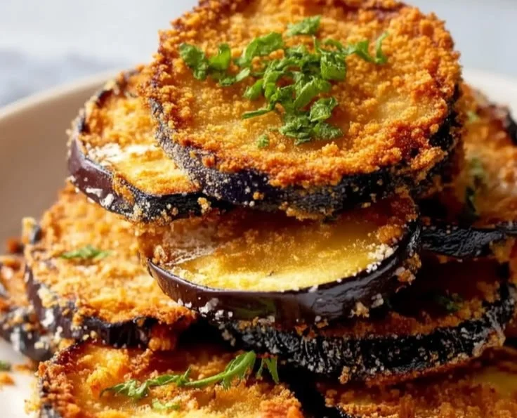 Garlic Parmesan Baked Eggplant served on a white plate with herbs