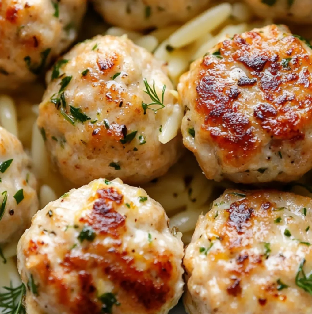 Plate of Greek Chicken Meatballs with lemon orzo and fresh herbs