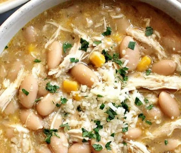 Bowl of healthy white chicken chili topped with cilantro and lime.