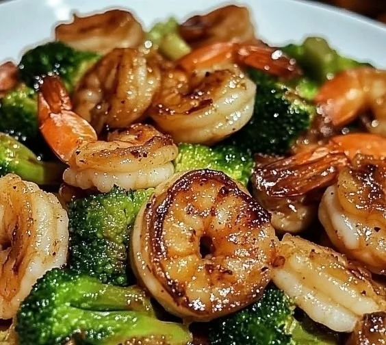 Delicious high-protein honey garlic shrimp served on a plate with vegetables.