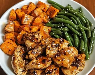Plate of Honey Garlic Chicken with sweet potato on a wooden table