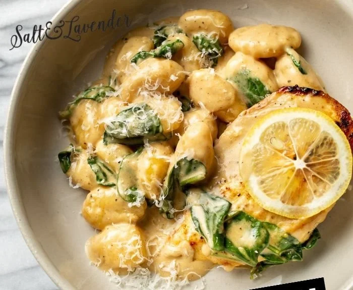 One Pan Lemon Chicken Gnocchi dish served in a skillet with lemon and herbs.