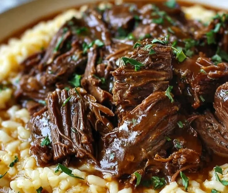 Slow-braised pot roast served with creamy Parmesan risotto on a rustic table.
