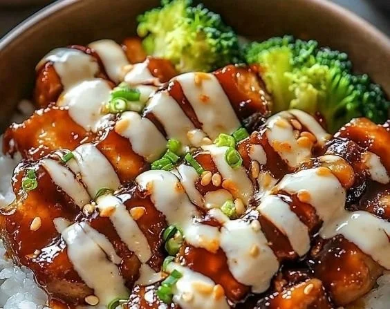 Delicious sticky chicken rice bowls garnished with fresh herbs and vegetables.