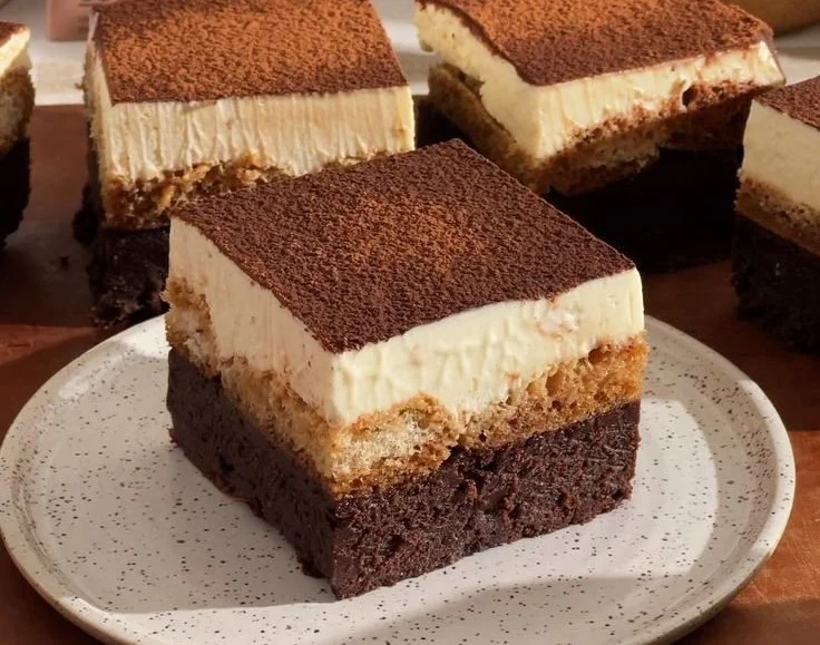 Delicious Tiramisu Brownies topped with cocoa and coffee drizzle.