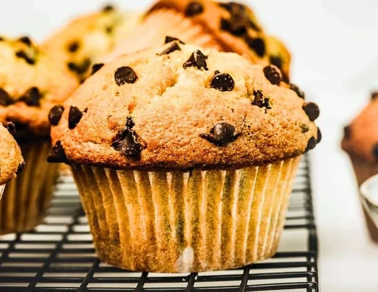 Freshly baked bakery-style chocolate chip muffins on a cooling rack