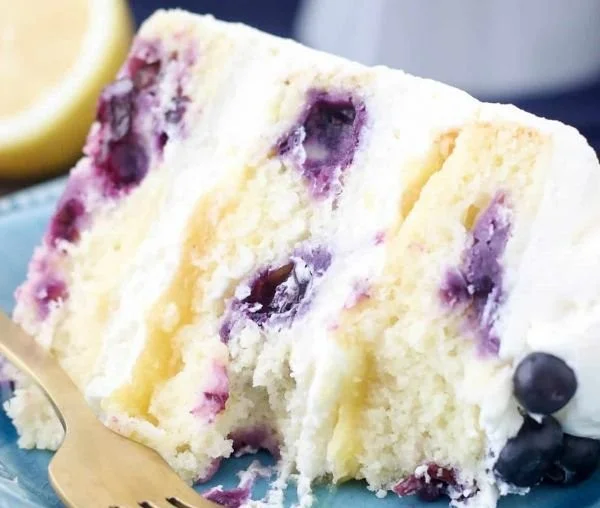 Delicious slice of BEST Lemon Blueberry Cake with fresh blueberries on top
