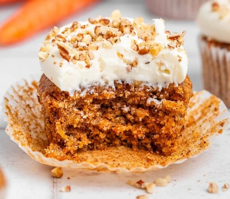 Delicious carrot cake cupcakes with cream cheese frosting and walnuts on top
