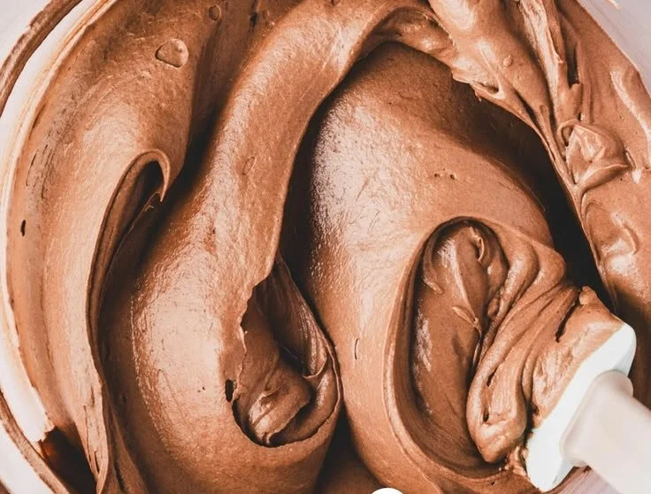 Delicious chocolate buttercream frosting spread on chocolate cake