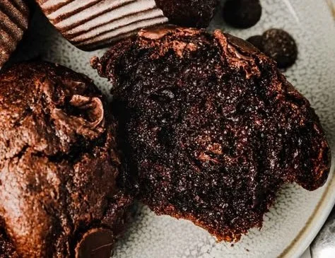 Delicious chocolate muffins with chocolate chips on a wooden surface