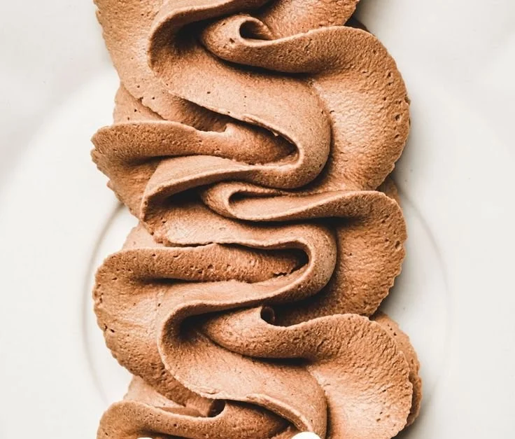 Delicious chocolate whipped cream frosting on a homemade cake