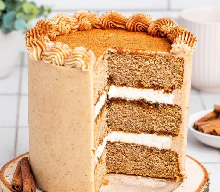 Homemade Cinnamon Roll Cake with icing on top, served on a white plate.