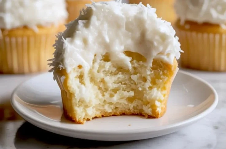 Delicious coconut cupcakes with creamy frosting and coconut flakes on top