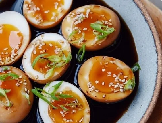 Delicious soy sauce eggs served on a plate with garnishes.