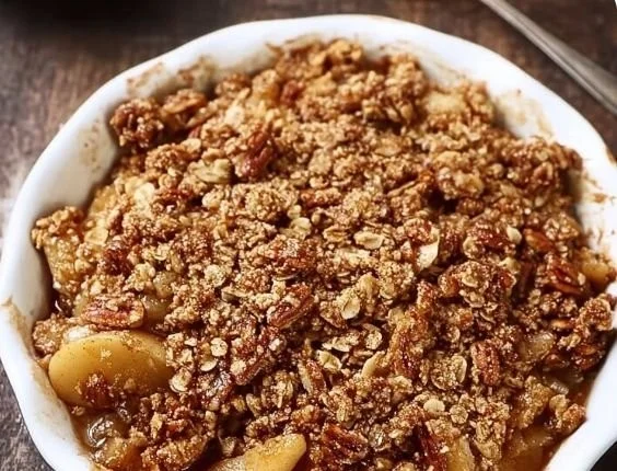 Healthy apple crisp with oatmeal pecan topping, served in a bowl.