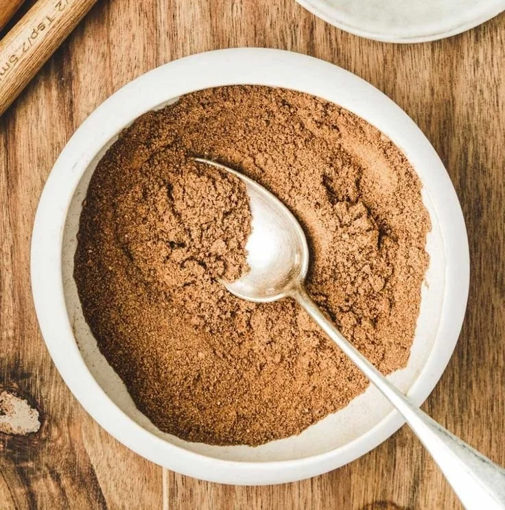 Homemade pumpkin pie spice blend in a jar with cinnamon and nutmeg