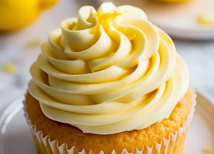 Delicious lemon buttercream frosting on a yellow cupcake