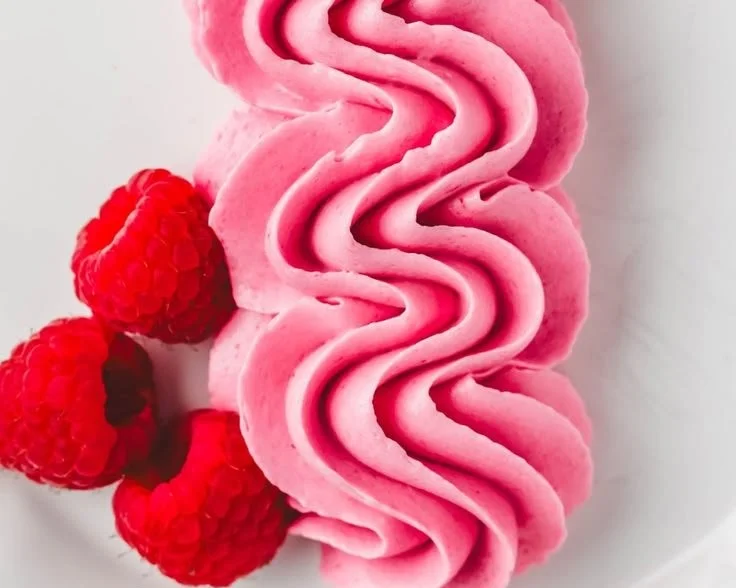 Delicious Raspberry Buttercream frosting spread on a cupcake.