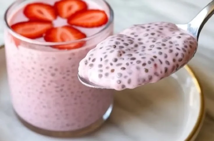 Bowl of strawberry chia seed pudding topped with fresh strawberries and mint leaves