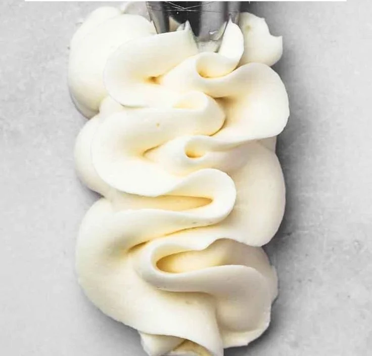 Deliciously creamy ultimate buttercream frosting on a cake