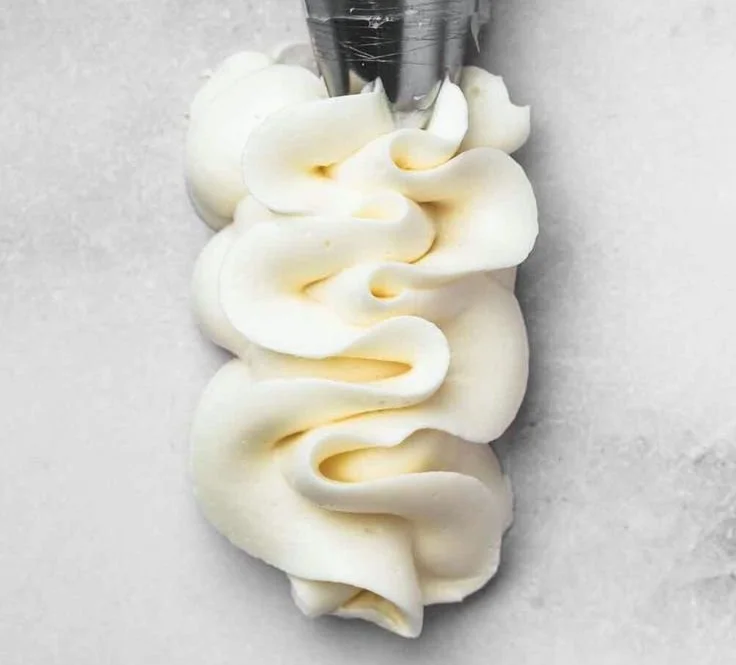 Delicious homemade vanilla buttercream frosting spread on a cake.