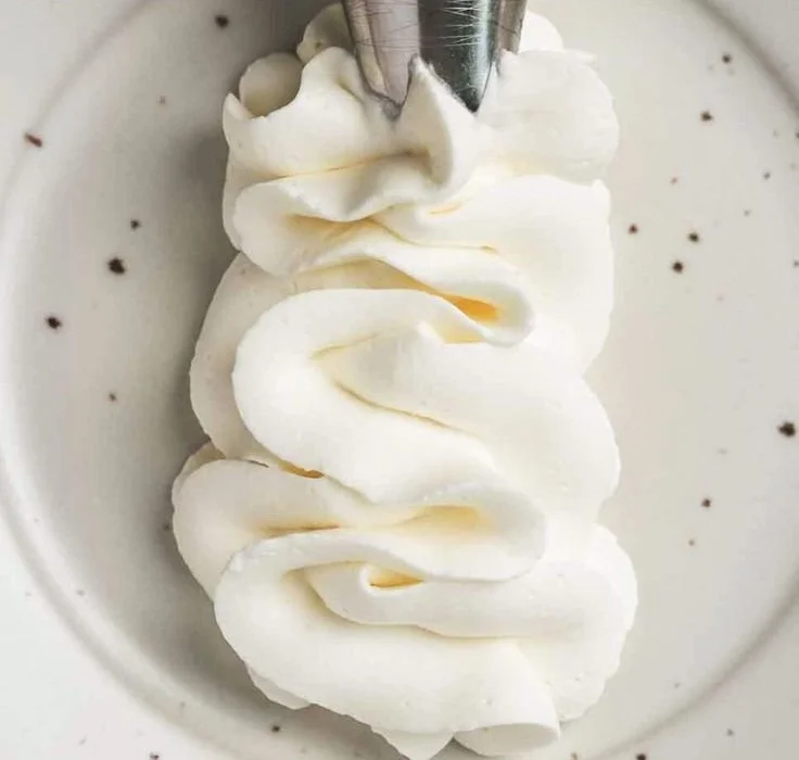 Delicious whipped cream cheese frosting topped on a chocolate cake