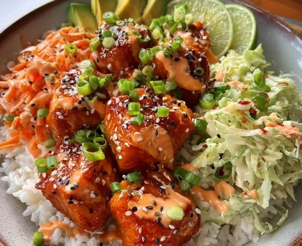 Bang Bang Salmon Bowls topped with fresh ingredients and a spicy sauce