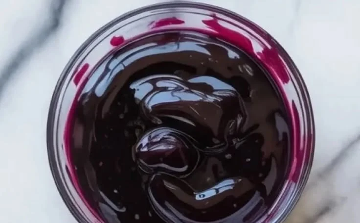 Homemade blueberry curd in a jar, showcasing vibrant color and creamy texture.