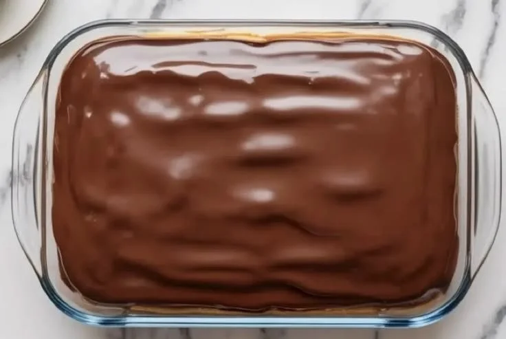 Boston Cream Pie Poke Cake with chocolate glaze and creamy custard filling