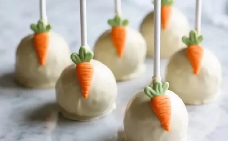 Delicious Carrot Cake Lollipops decorated with cream cheese frosting.