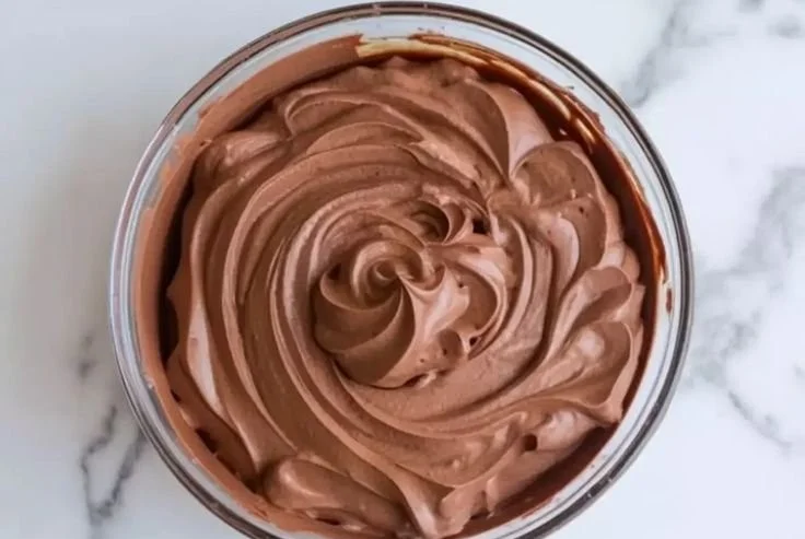Delicious chocolate mousse used as cake filling, rich and creamy dessert.