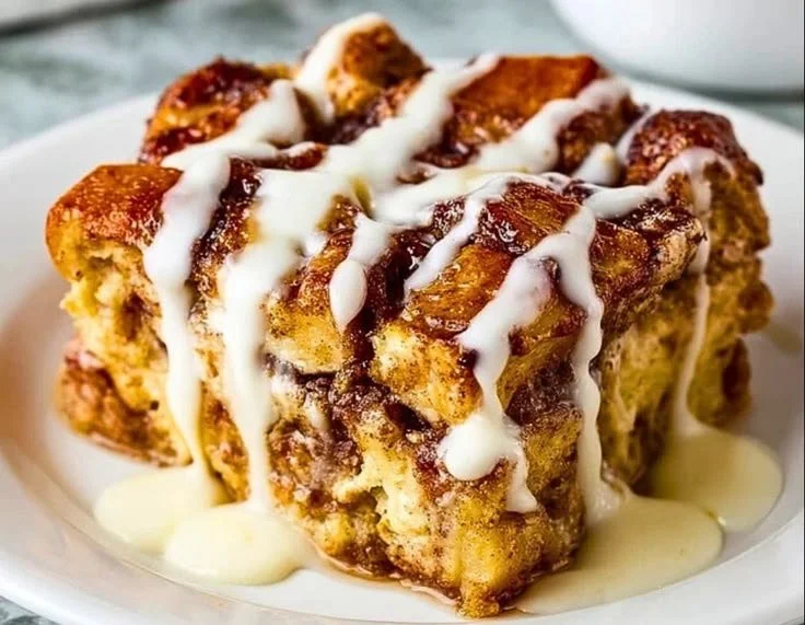 Cinnamon Roll French Toast Casserole topped with icing and berries