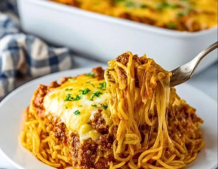 Delicious cream cheese spaghetti bake served in a dish, topped with melted cheese.