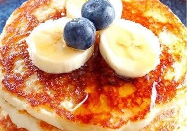 Fluffy Greek yogurt pancakes served with berries and syrup on a plate