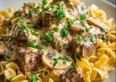 Creamy Crock Pot beef stroganoff served in a bowl with fresh parsley garnish.