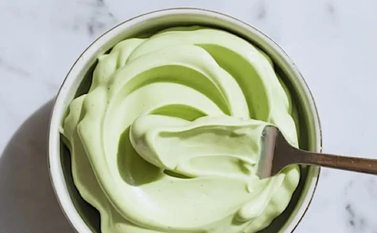 A slice of Pistachio Mascarpone Cake showcasing its creamy filling and pistachio topping.