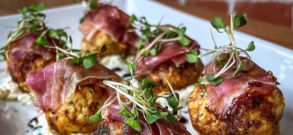 Prosciutto-wrapped goat cheese bonbons appetizer on a plate