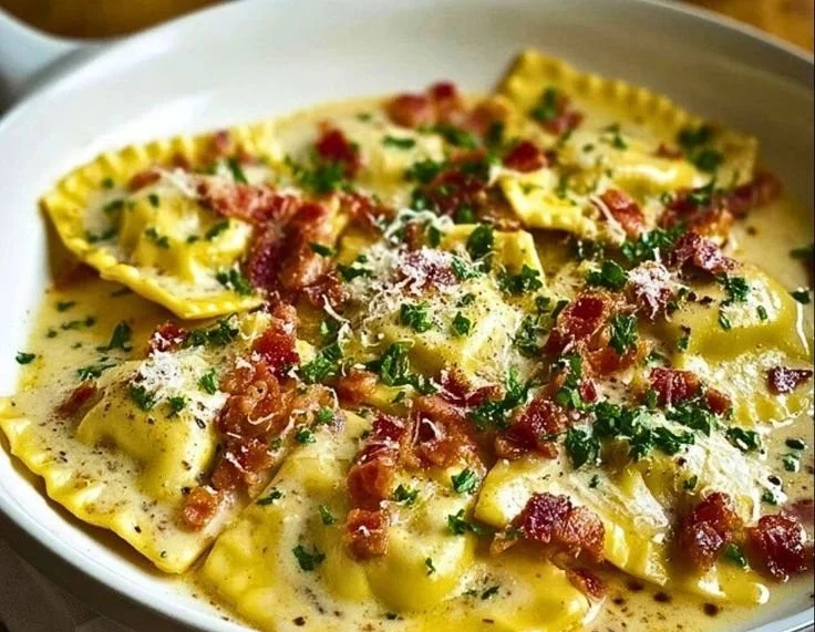Delicious plate of homemade Ravioli Carbonara topped with parmesan and herbs.