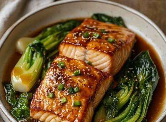 A beautifully plated salmon fillet glazed with miso and butter, garnished with herbs.
