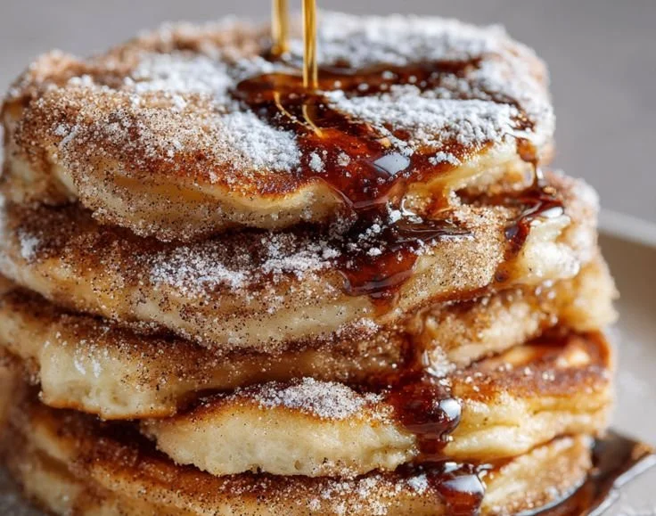 Delicious Spanish churro pancakes topped with cinnamon sugar and chocolate sauce.