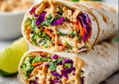 Thai Peanut Chicken wraps with fresh vegetables and peanut sauce