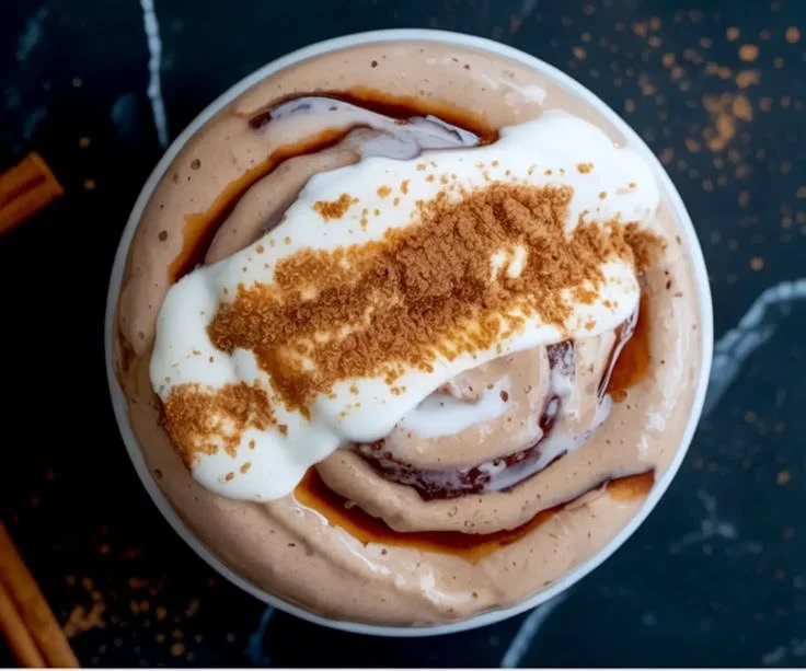 Cinnamon roll smoothie bowl topped with cinnamon and nuts in a bowl.