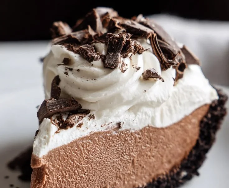 Delicious slice of French Silk Pie topped with whipped cream and chocolate shavings