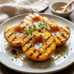 Delicious grilled peaches served on a plate, showcasing their caramelized texture.
