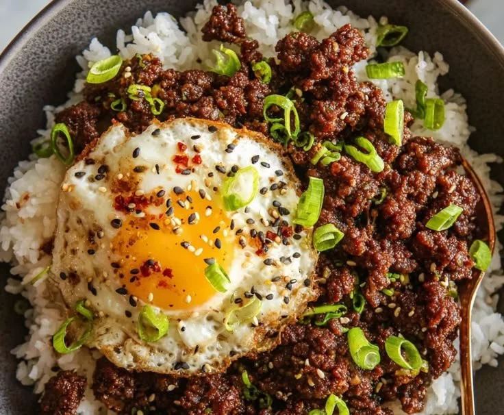 Korean-Style Ground Beef Bowls topped with fresh vegetables and sesame seeds.