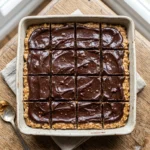 Delicious no-bake peanut butter bars cut into squares on a wooden table.